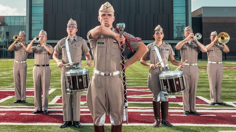 Cade Mahlen ’24 standing with other band members in formation on the Aggie Band practice field