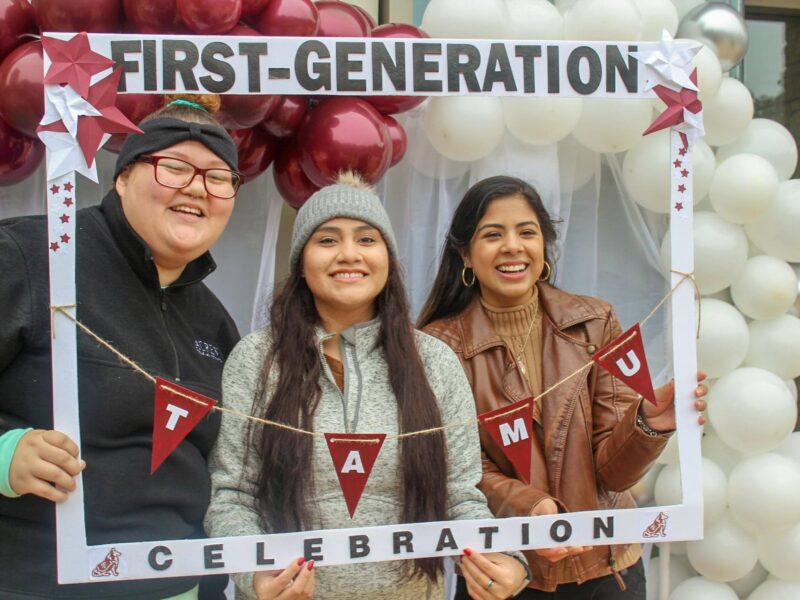 a family poses in a frame that says first-generation celebration, TAMU
