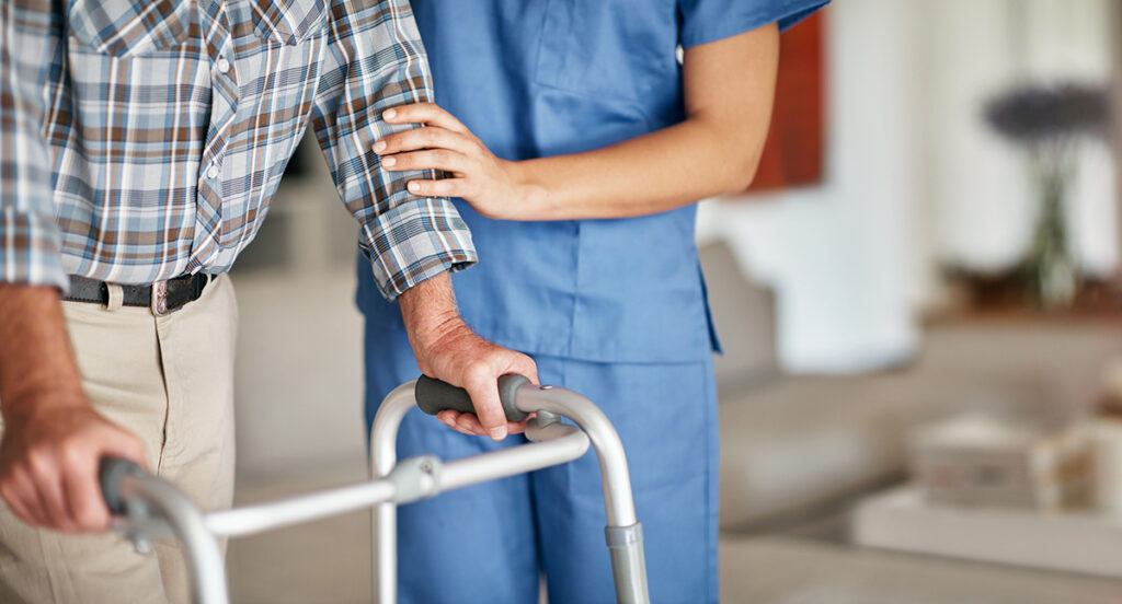 a health care worker helping a patient with a walker