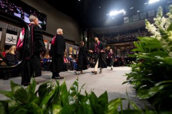 A photo of a student walking across the stage at graduation