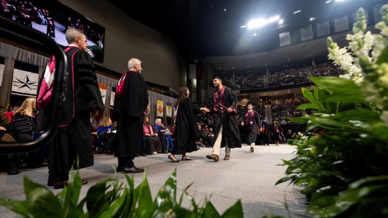 A photo of a student walking across the stage at graduation