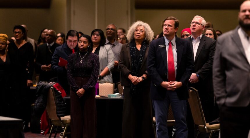 a photo of Dr. Angela Davis standing next to students and other attendees during the annual MLK Breakfast