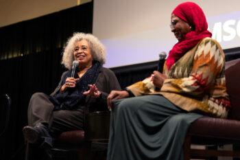 a photo of Dr. Angela Davis and Rebecca Hankins sitting next to each other holding microphones