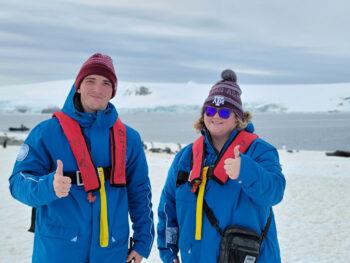 two group members giving a gig em in Antarctica