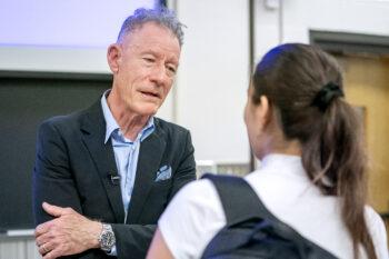 A photo of Lyle Lovett talking to a student.