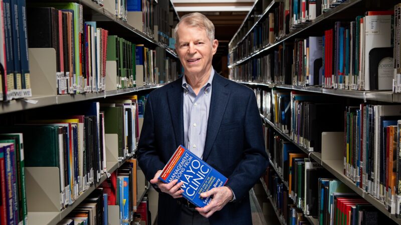 A photo of Dr. Leonard Berry standing among books in a library.