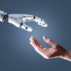 An illustration of a human hand reaching out to a robotic hand.
