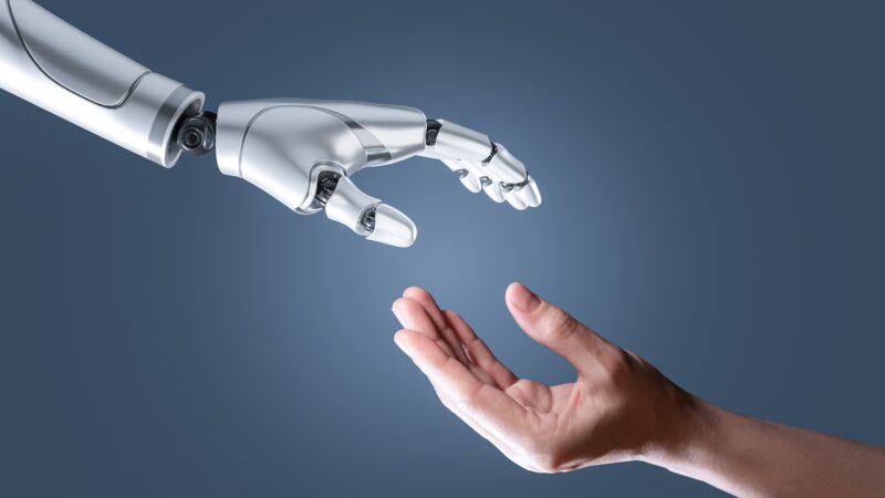 An illustration of a human hand reaching out to a robotic hand.