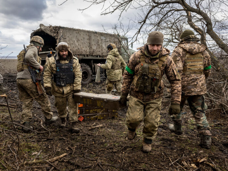 a photo of men in military uniforms unloading boxes of munitions from a truck in Ukraine