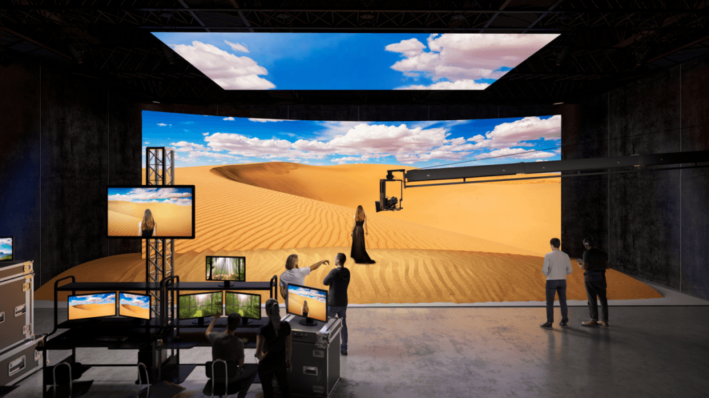 A photo of a virtual production studio and LED wall showing computer-generated imagery combined with a woman being filmed on a stage.