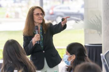 A photo of Dr. Elsa Murano pointing to the crowd during a presentation.
