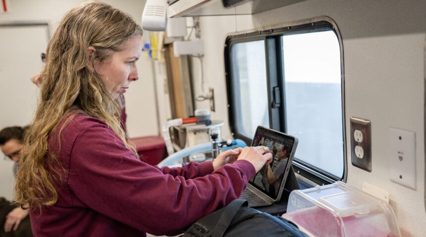 A photo of a member of the Veterinary Emergency Team working in a mobile trailer.
