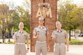 A photo of three cadets in uniform standing in front of the arches on The Quad at Texas A&M University.