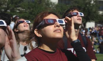 Aggies watching the last solar eclipse with Libraries' viewing glasses