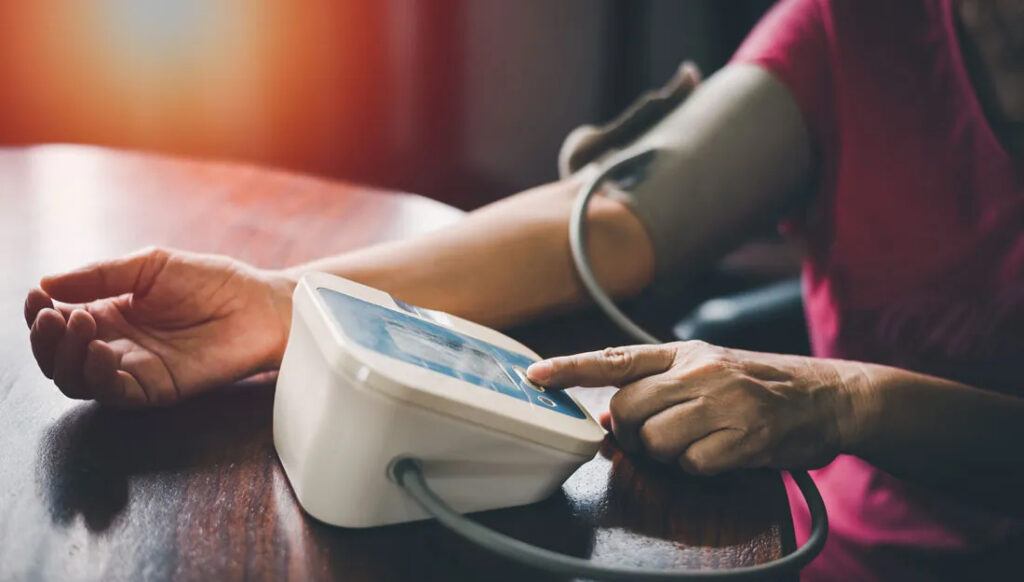 A photo of a person using a home blood pressure system.