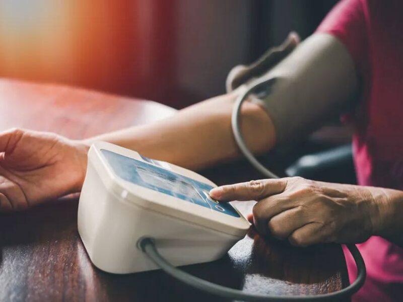 A photo of a person using a home blood pressure system.