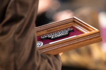 Close up image of a person holding a plaque in their hands that reads "President's Meritorious Service Award"