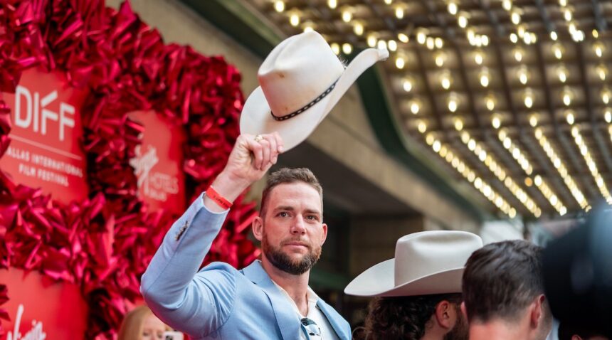 Cody Jones tips his cowboy hat to the crowd on the red carpet