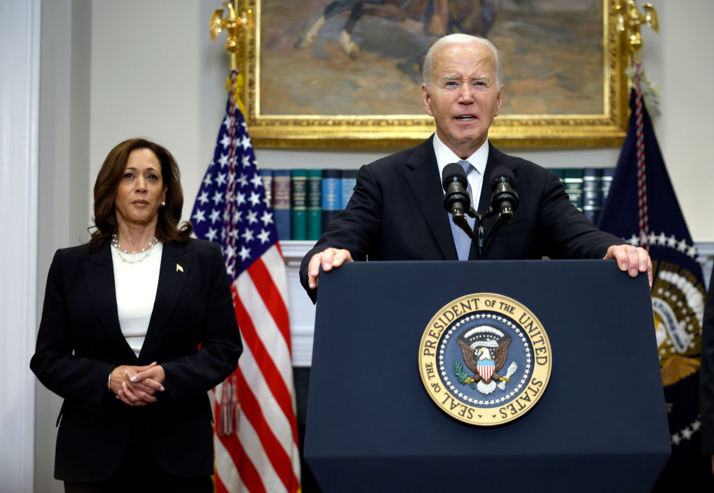 President Joe Biden speaking at a lectern as Vice President Kamala Harris stands in the background. Biden recently announced his decision to drop out of the 2024 race for the White House, ending his bid for reelection.