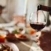 close up of a man pouring red wine in a glass