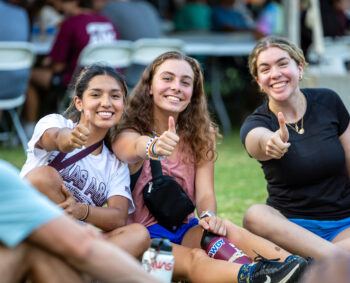 three students show gig em thumbs up at 2023's President's Picnic during Howdy Week