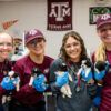 Four members of the Veterinary Emergency Team hold a litter of puppies.