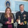 A photo of two award winners standing with their awards.