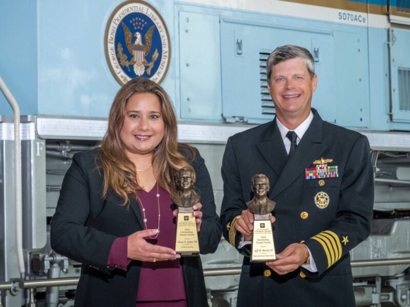 A photo of two award winners standing with their awards.