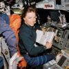 A photo of an astronaut at the controls of a space shuttle.