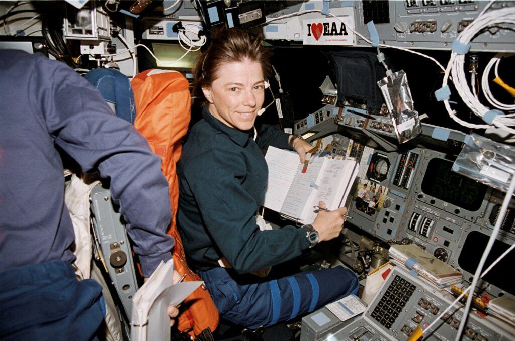 A photo of an astronaut at the controls of a space shuttle.