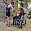 two clinic participants preparing to climb the rock wall at the Rec Center during training before launch