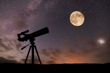 a telescope, the moon and a starry sky