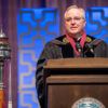 Mark Welsh speaking at a podium in academic regalia at his presidential investiture