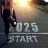 A runner stretching on a road with the words 2025 Start at her feet and a sunrise in the distance.