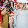 A man looking at his phone while shopping in a mall during the Christmas shopping season.