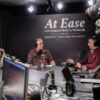 Three people recording a podcast in a studio surrounded with computer equipment, microphones and cameras.