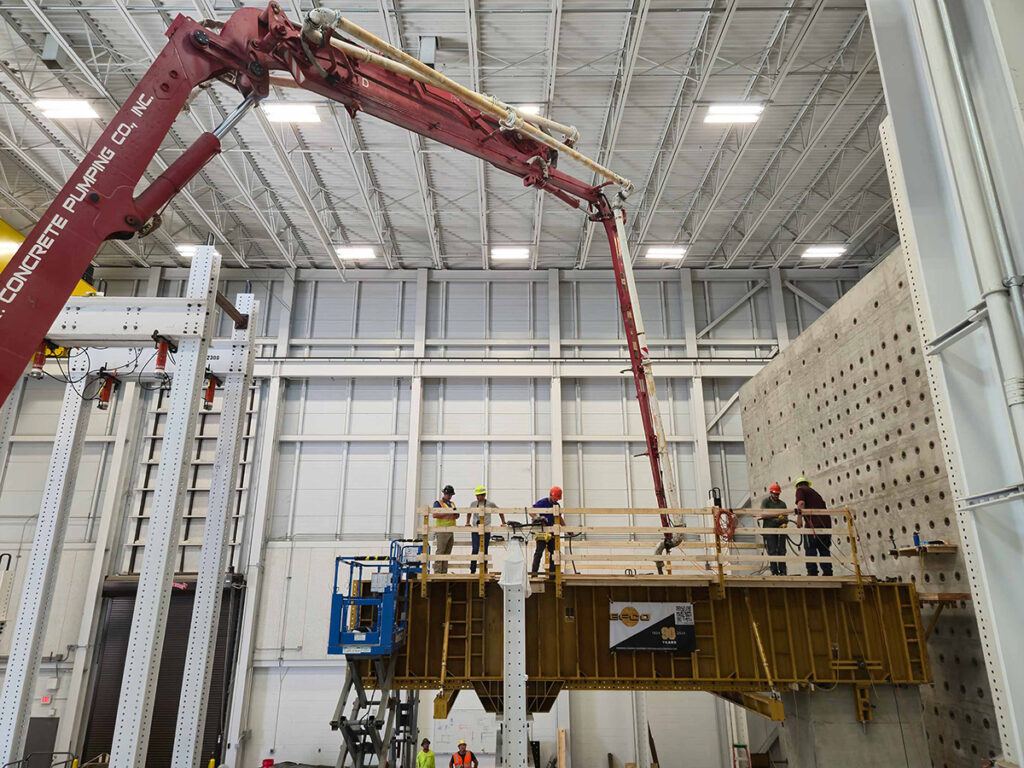 Researchers replicate a construction sequence using a concrete pump truck and structural formwork to cast the straddle bent at full scale.