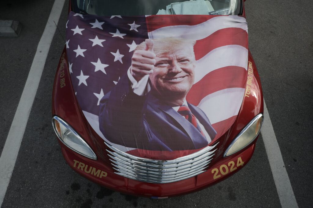 A flag of President-elect Donald Trump sits on the hood of a car near his Mar-a-Lago resort on December 12, 2024, in Palm Beach, Florida.