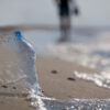 a rendering of a plastic bottle breaking apart on the beach