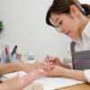 Nail stylist working on someone's fingernails.