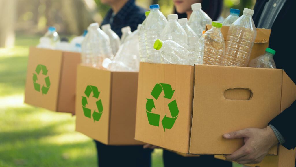 A photo of people holding boxes of recyclable plastic containers.