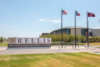 A photo of the sign and flag at the entrance of Brian's Texas A & M Relis Campus.