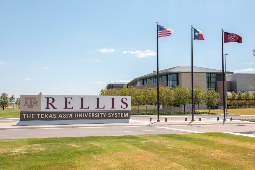 A photo of the sign and flags at the entrance to the Texas A&M-RELLIS campus in Bryan.