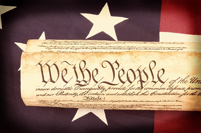 The Constitution with a U.S. flag background