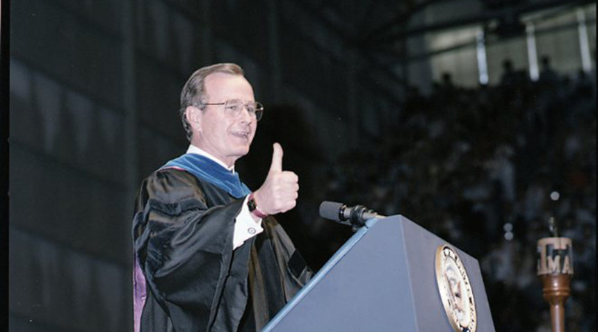a photo of George H.W. Bush giving the thumbs up at a graduation ceremony