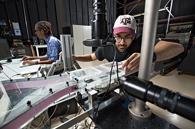 Alireza Hooshanginejad (right) adjusts the miniature wind tunnel, as Roger Simon (left) runs the Labview code to control the wind speed.