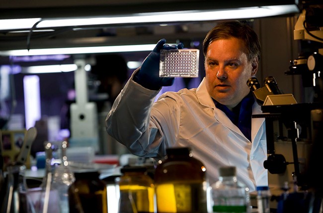 Scientist examining device in lab