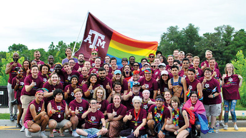 Group picture of students with TAMU rainbow flag
