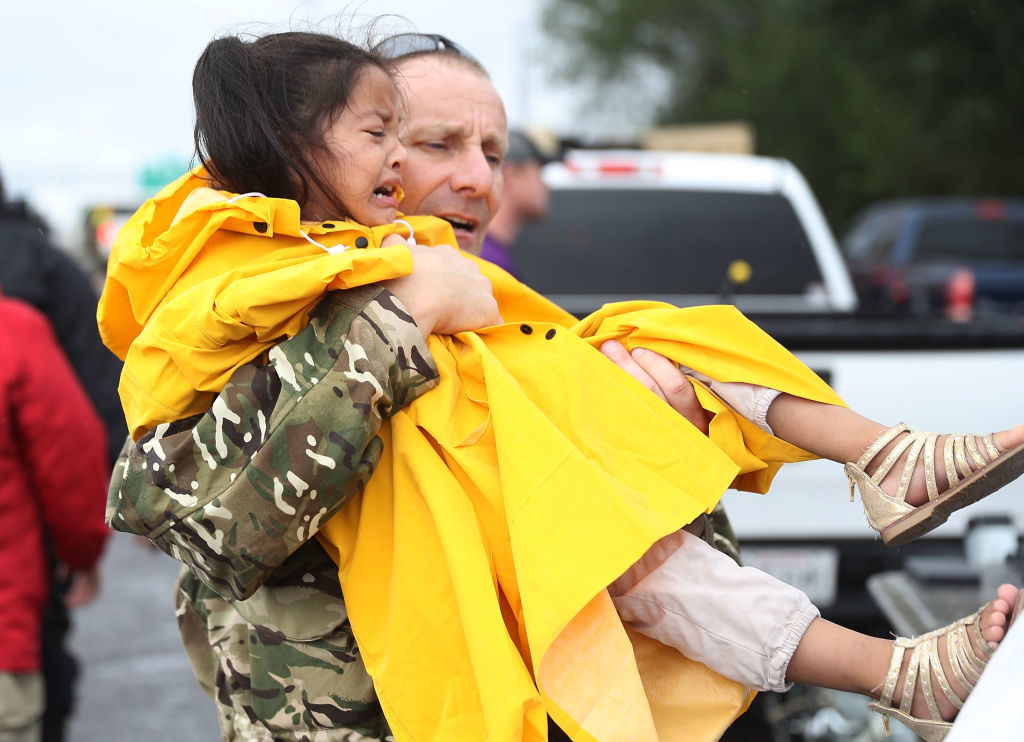 Bush School faculty member Richard MacNamee carries a girl to safety from the flooding of Hurricane Harvey on August 30, 2017 in Port Arthur, Texas. (Photo by Joe Raedle/Getty Images)