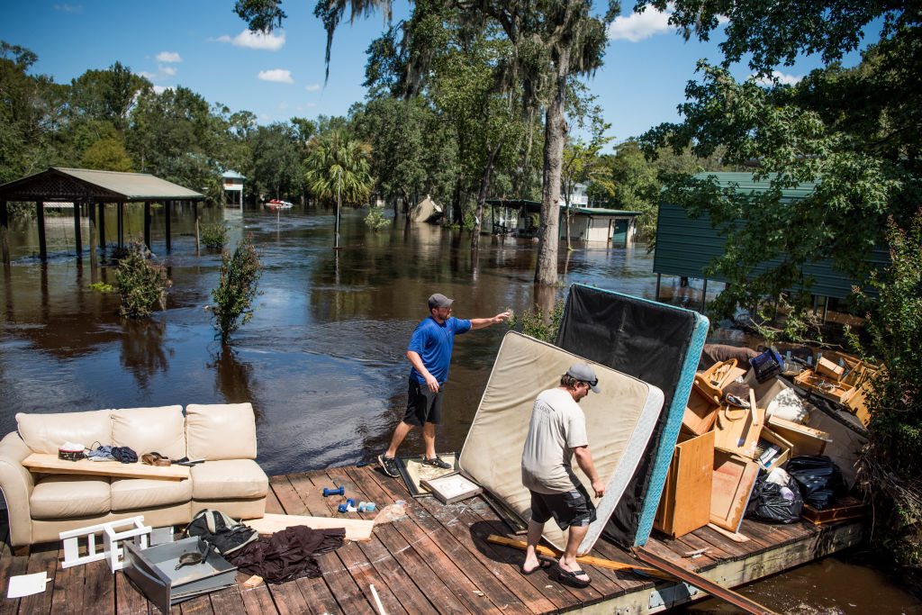 Marc St. Peter, left, and Chris Wisor lend a hand cleaning up as floodwaters from Hurricane Irma recede September 13, 2017 in Middleburg, Florida. (Photo by Sean Rayford/Getty Images)